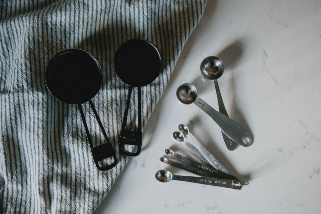 Measuring cups and tiny measuring spoons for cheesemaking.