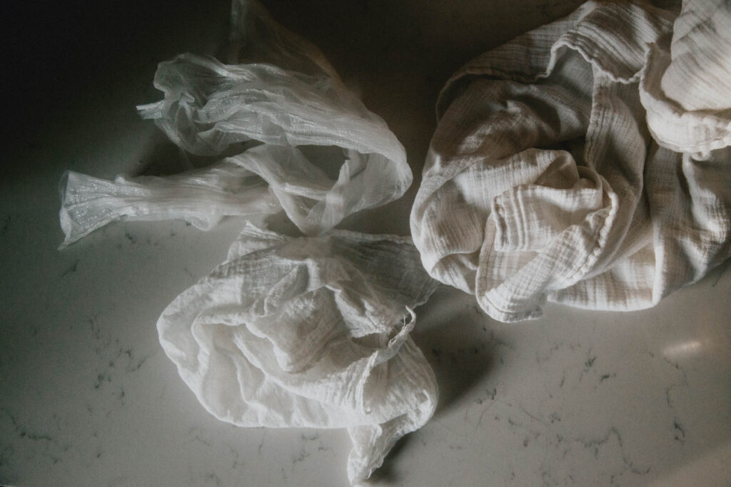 Three different kinds of cheesecloth sit swirled on top of a countertop.