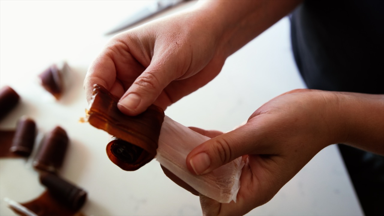 A reddish brown ginger peach fruit leather is unrolled.