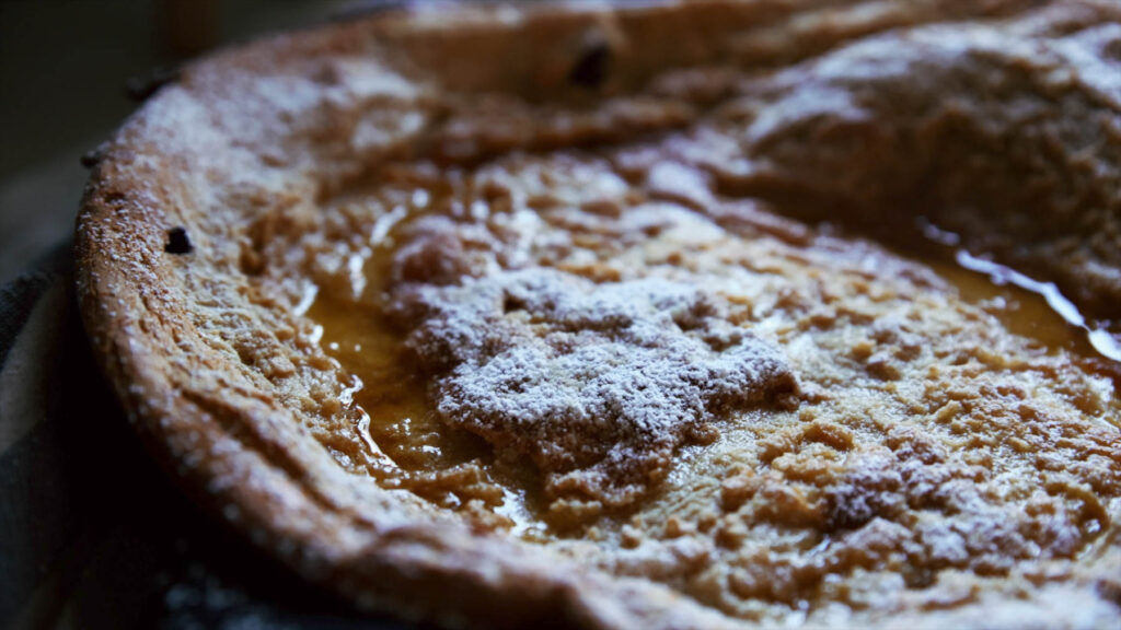 A decadent brown butter chocolate chip dutch baby close-up.