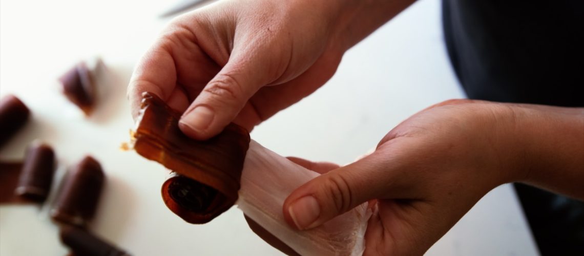 A reddish brown ginger peach fruit leather is unrolled.